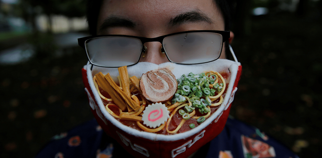 Japanese designer Takahiro Shibata's glasses fog up as he wears a protective mask that looks like a steaming bowl of ramen noodle soup. Credit: Reuters Photo