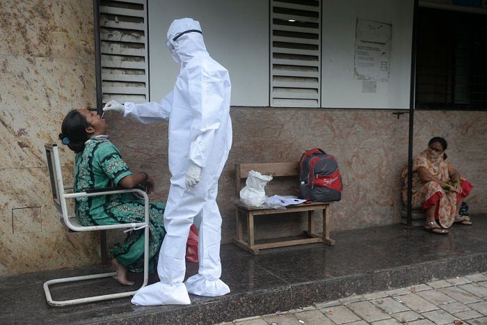 A health worker takes a throat swab during a Covid-19. Credits: AFP Photo