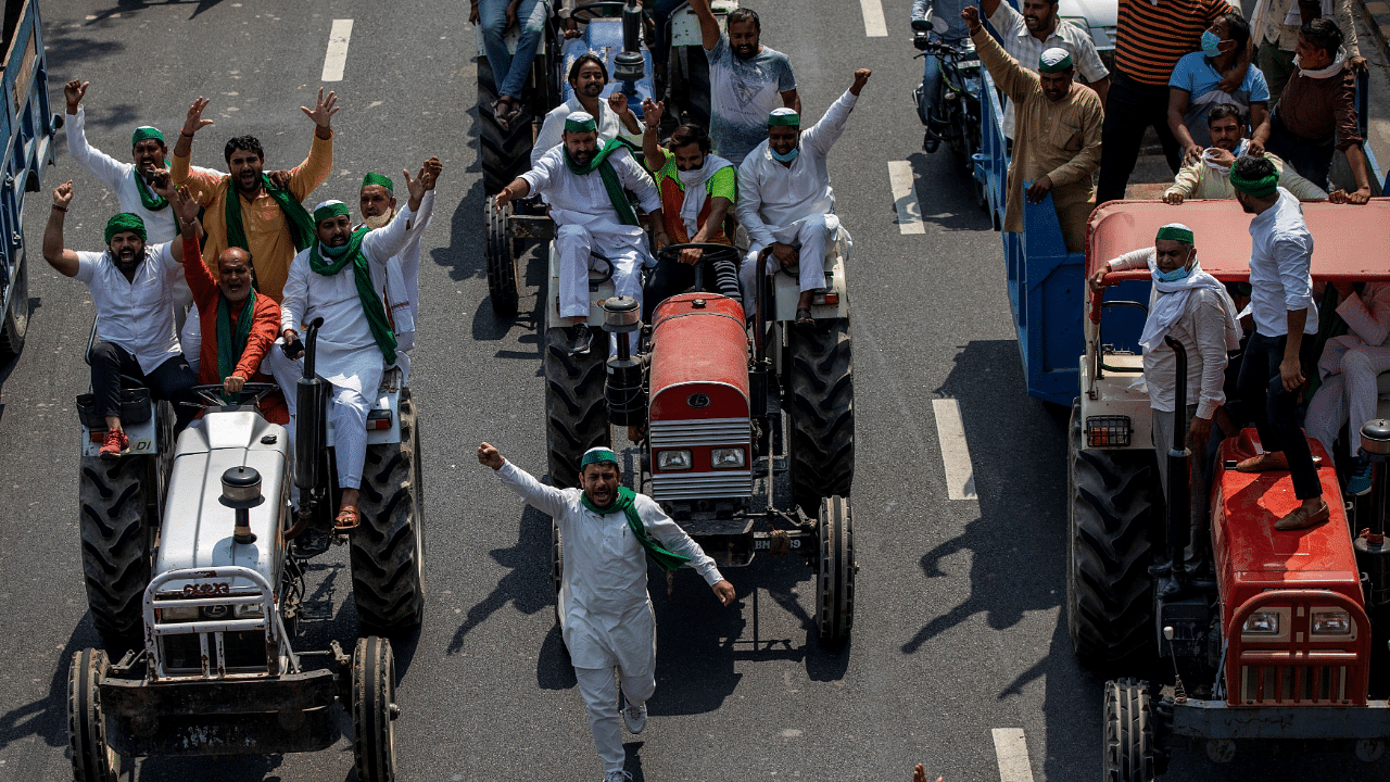 Farmers on tractors shout slogans as they arrive to block the Delhi-Uttar Pradesh border during a protest against Farm Bills. Credits: Reuters Photo