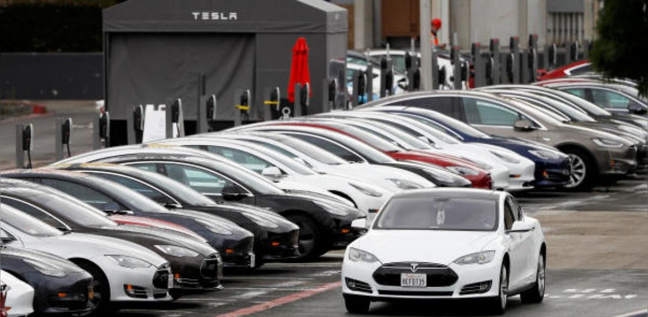 A Tesla Model S electric vehicle drives along a row of occupied superchargers at Tesla's primary vehicle factory. Credit: Reuters photo