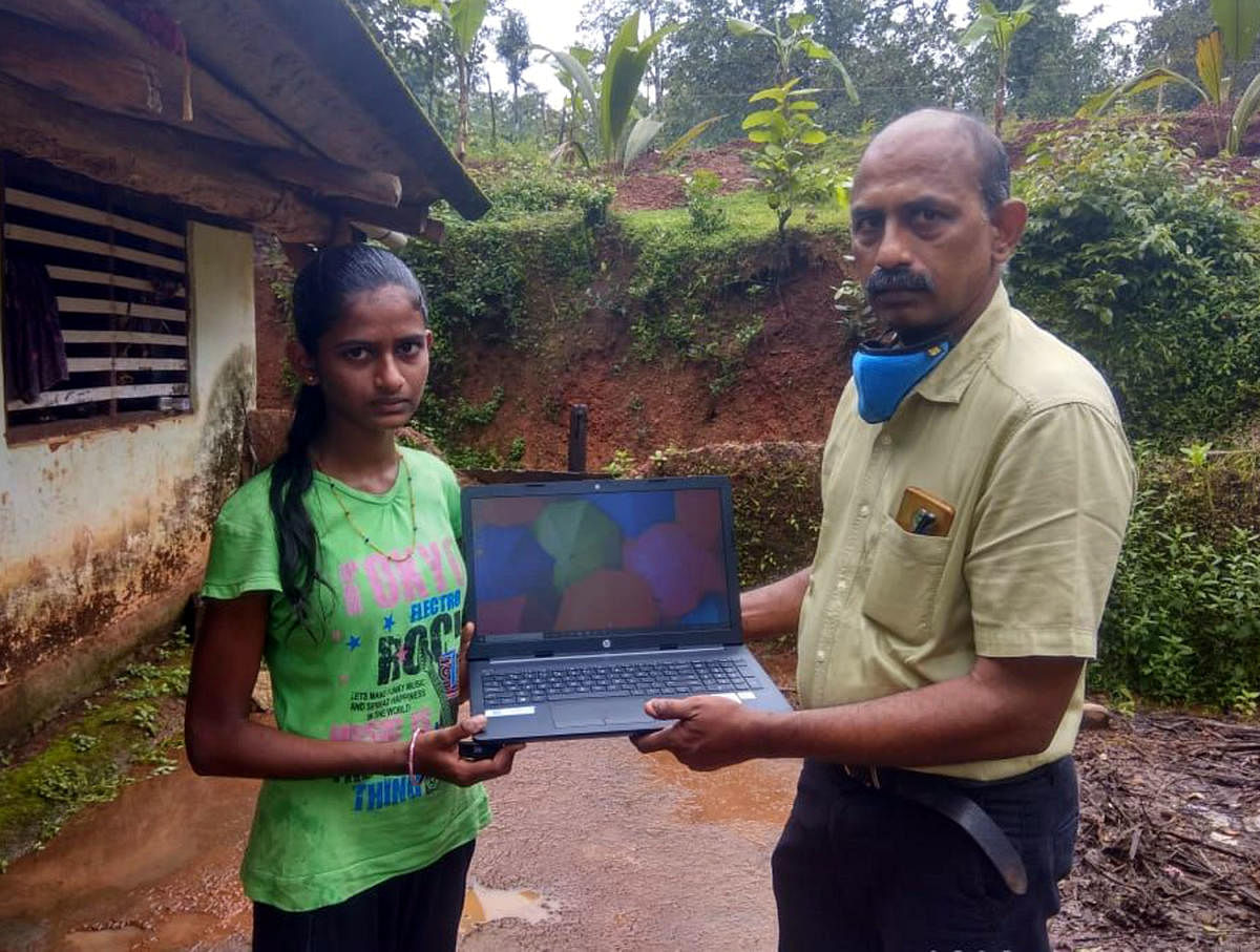 An Infosys officer hands over a laptop for Bhoomika at Kunjnadi in Kundapura taluk.