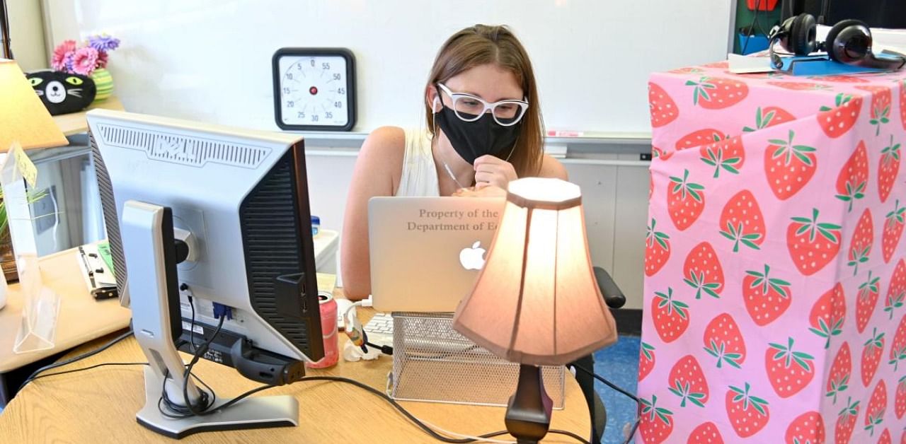  A teacher wears a mask and teaches remotely from her classroom. Credit: AFP