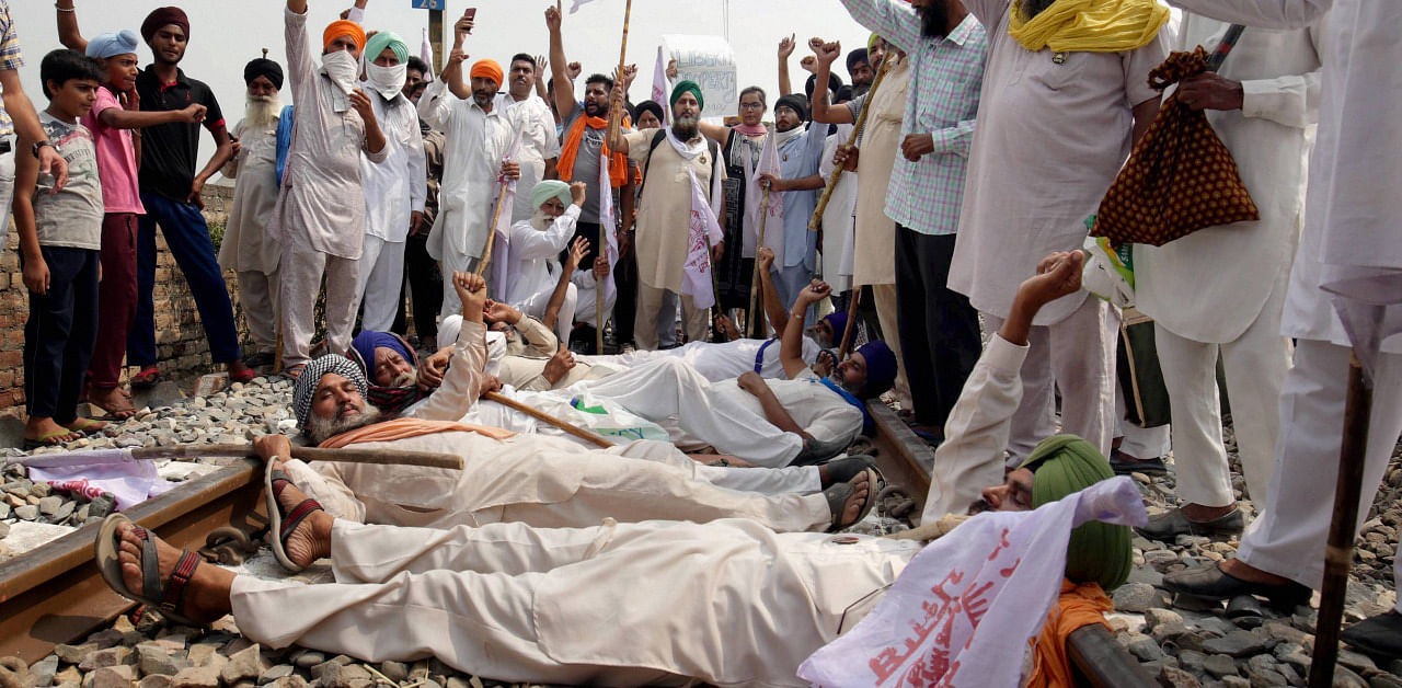 Farmers block a railway track as they participate in 'Rail Roko Andolan' during a protest against the farm bills passed in both the Houses of Parliament recently in at village Devi Dass Pura, about 20km from Amritsar. Credit: PTI Photo