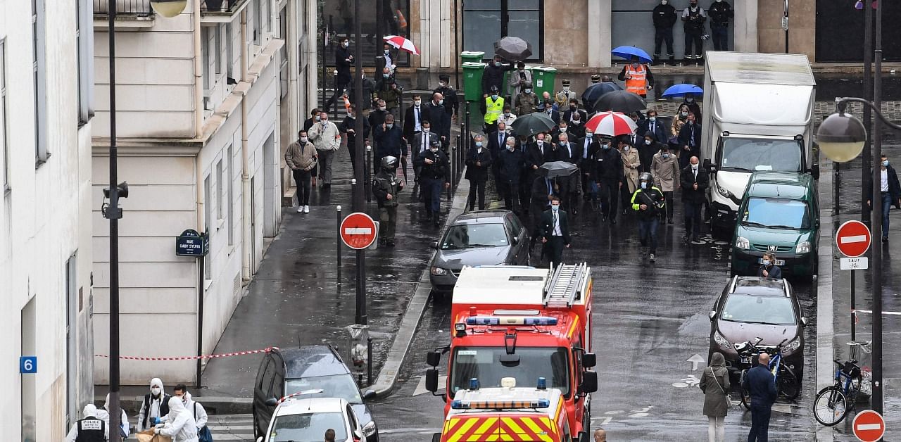 French Prime Minister Jean Castex (C), French Interior minister Gerald Darmanin (C-L) and the Mayor of Paris Anne Hidalgo (C-R) arrive at the scene where several people were injured near the former offices of the French satirical magazine Charlie Hebdo. Credit: AFP Photo