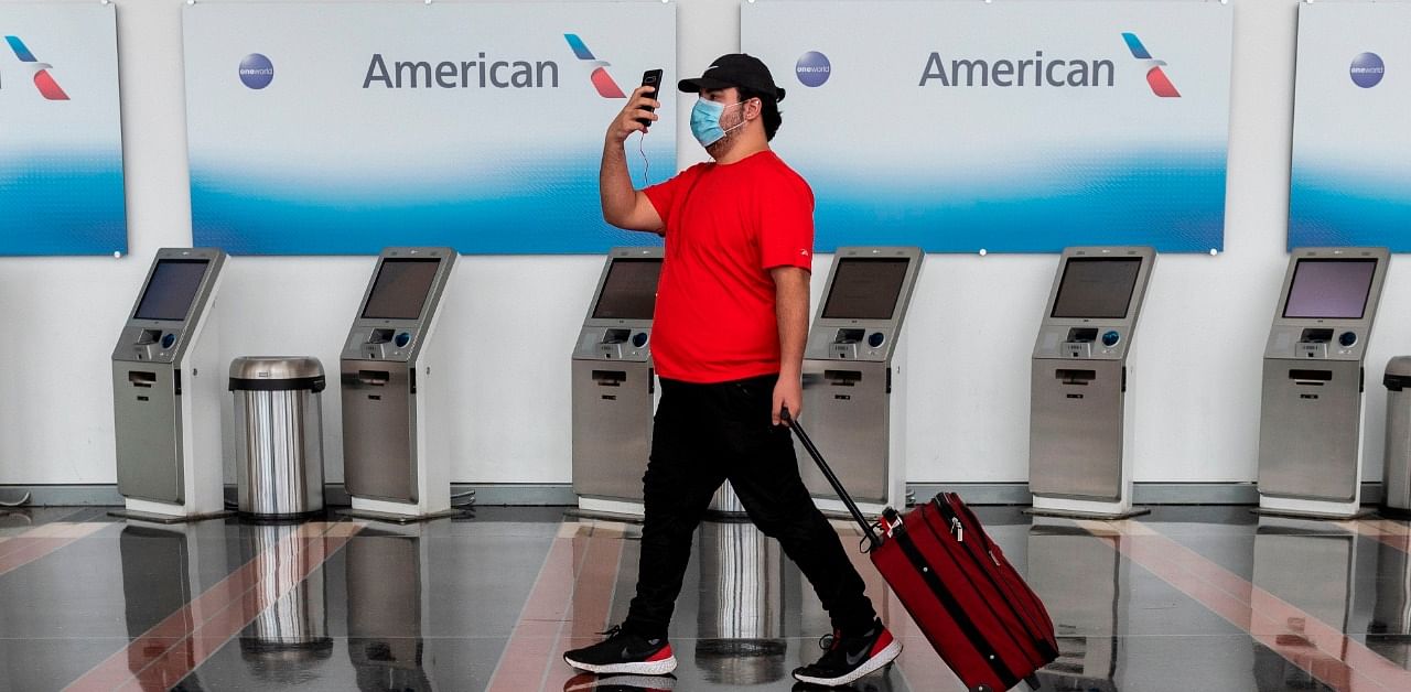 A passenger walks past empty American Airlines check-in terminals. Credit: AFP Photo