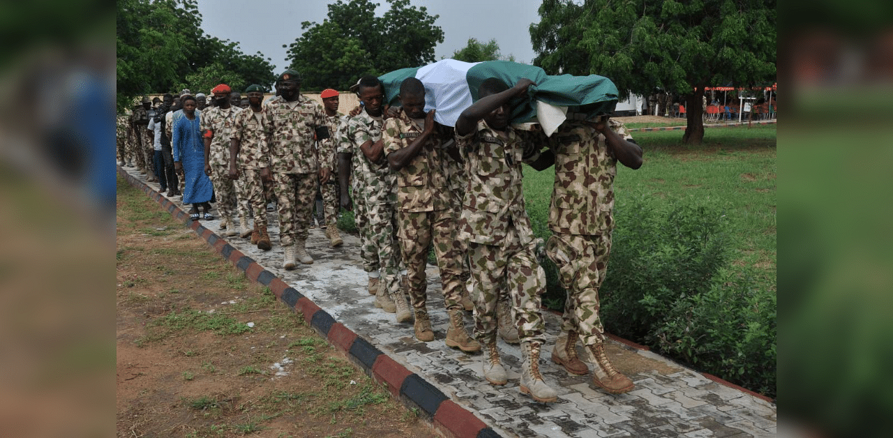 Nigerian soldiers carry the body of a fellow serviceman during his funeral on September 26, 2020 as victims are buried following the attack on vehicles carrying Borno governor Babagana Umara Zulum near the town of Baga on the shores of Lake Chad. Credit: AFP Photo