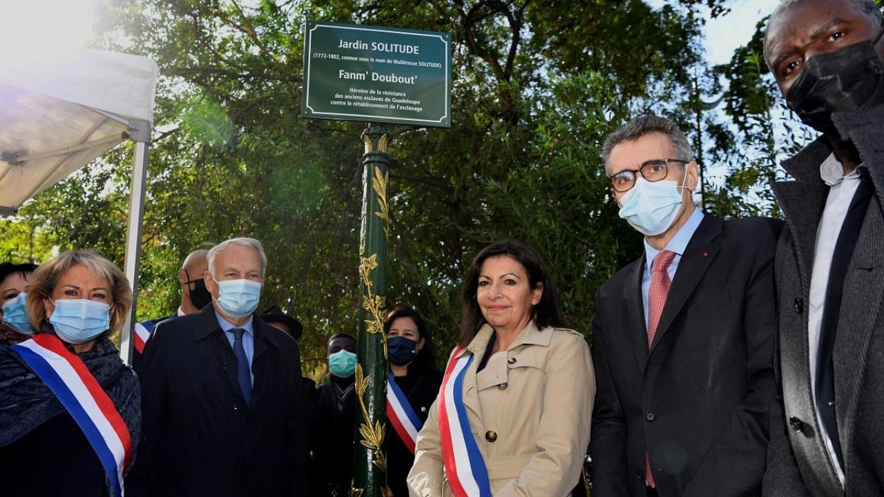 Paris mayor Anne Hidalgo (C) poses next to Jean-Marc Ayrault President of the Foundation for the Memory of Slavery, during the inauguration ceremony of the "Jardin Solitude" named after a historical figure and heroine in the fight against slavery on French Guadeloupe in Paris. Credit: AFP.