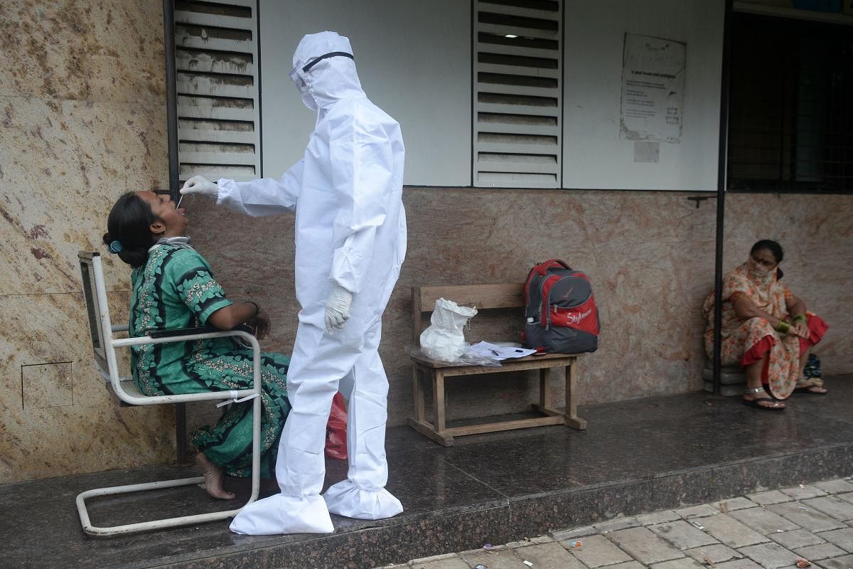 A health worker takes a throat swab during a Covid-19 screening in Mumbai. Credit: PTI