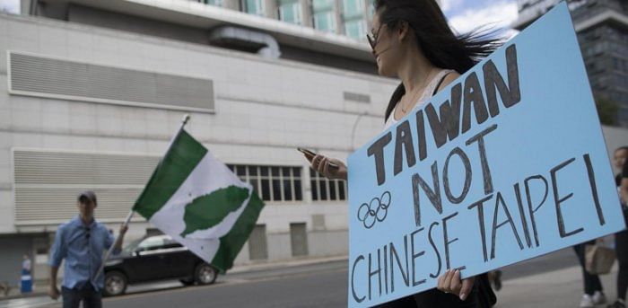 Demonstrators carry signs and a Taiwan Independence flag as the walk past Consulate General of China. Credit: AP
