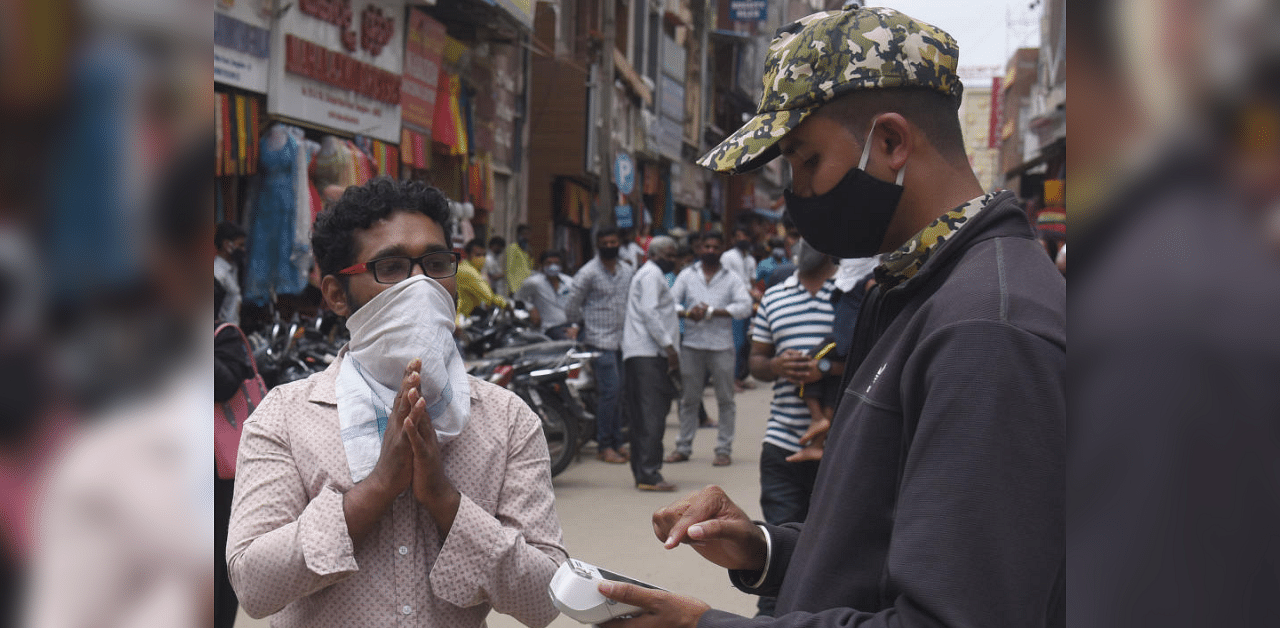 BBMP Marshals collecting fine from people who are not wearing proper mask as per Covid 19 lockdown norms in Bengaluru. Credit: DH Photo