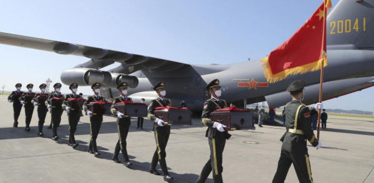 South Korea Defense Ministry, Chinese honor guard members with caskets containing the remains of Chinese soldiers move into a cargo airplane during the handing over ceremony at the Incheon International Airport in Incheon, South Korea. Credit: AP Photo
