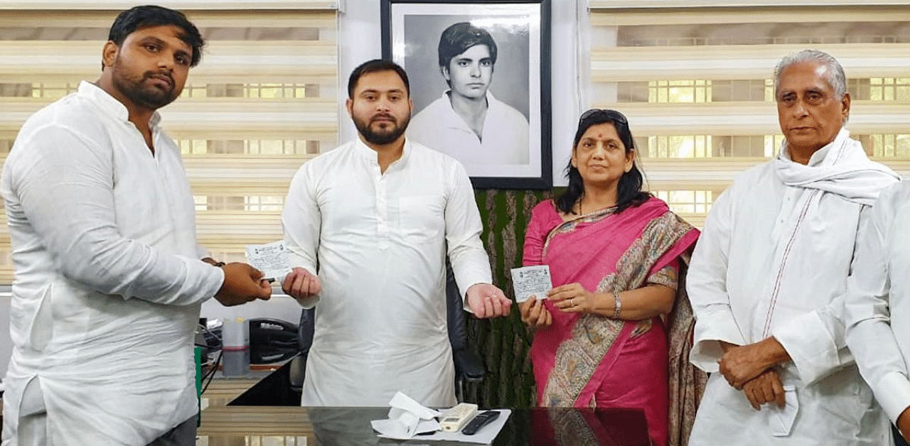 RJD leader Tejashwi Yadav presents party member slip to former MP Lovely Anand as she joins the party, ahead of Bihar Assembly elections, in Patna. Credit: PTI Photo