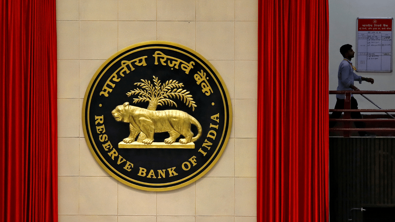 A worker walks past the logo of Reserve Bank of India inside its office in New Delhi. Credits: Reuters Photo