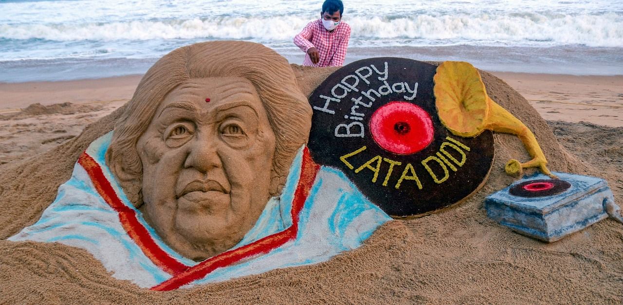 Sand artist Sudarsan Pattnaik gives final touch to the sand sculpture of veteran singer Lata Mangeshkar on the eve of her birthday, in Puri. Credit: PTI Photo