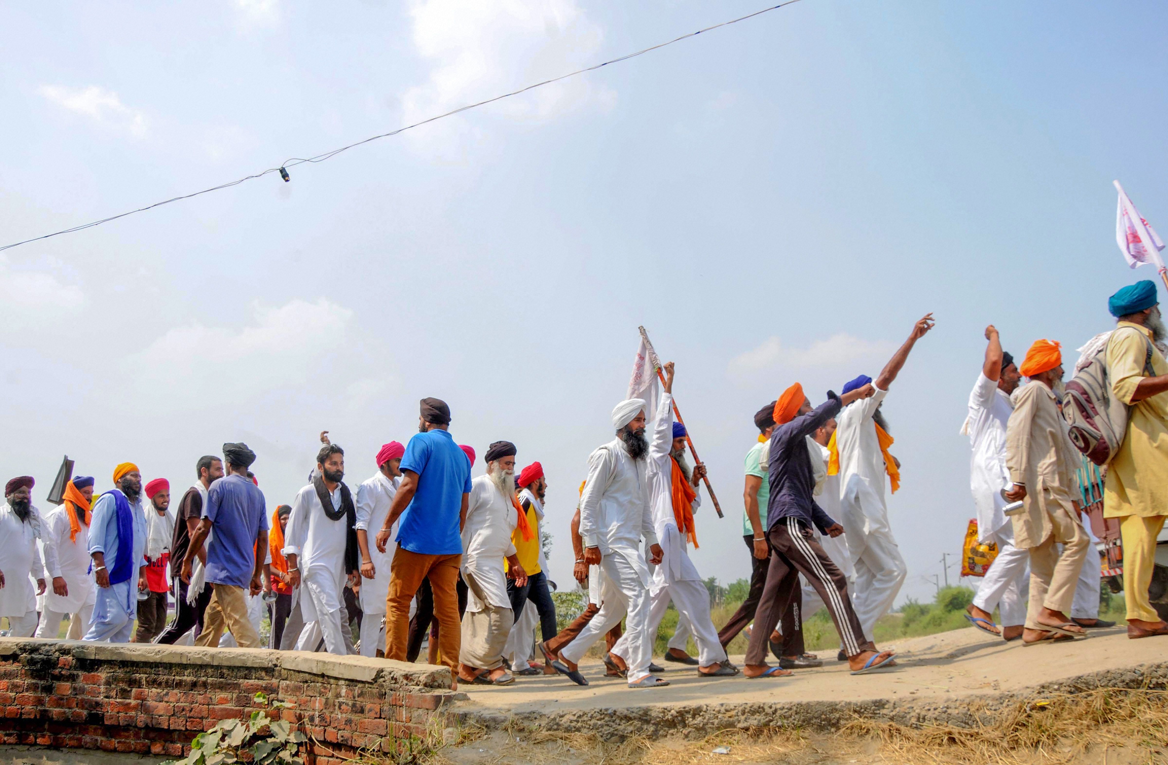Protestors raise slogans as they arrive to join farmers in their ongoing 'Rail Roko' or 'Stop the Trains' agitation against farm laws. Credits: PTI Photo