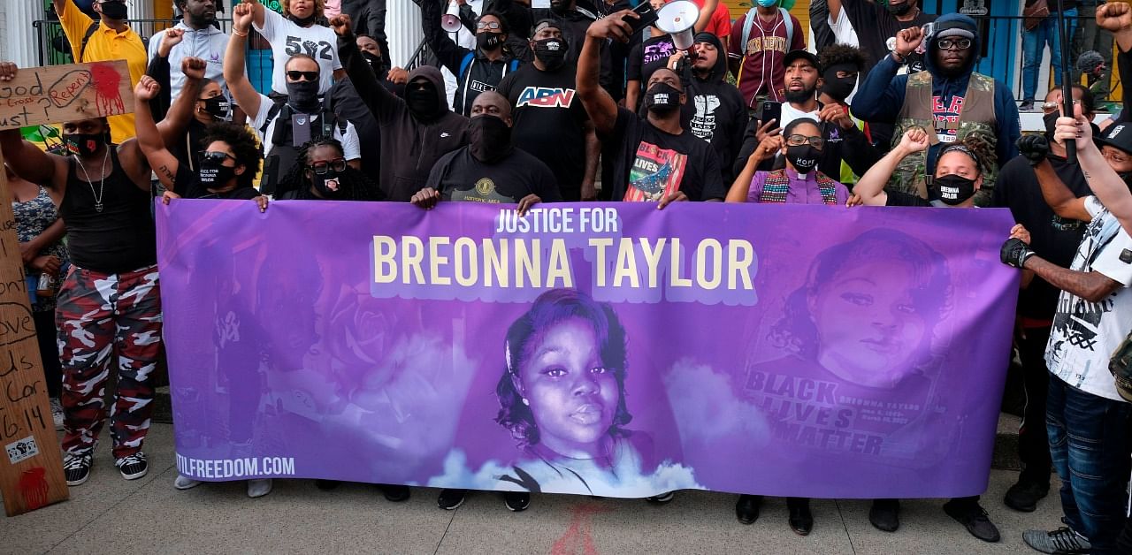 Demonstrators pose for a photo in front of a local restaurant in the NULU neighborhood on a third day of protest over the lack of criminal charges in the police killing of Breonna Taylor and the result of a grand jury inquiry, in Louisville, Kentucky. Credit: AFP Photo
