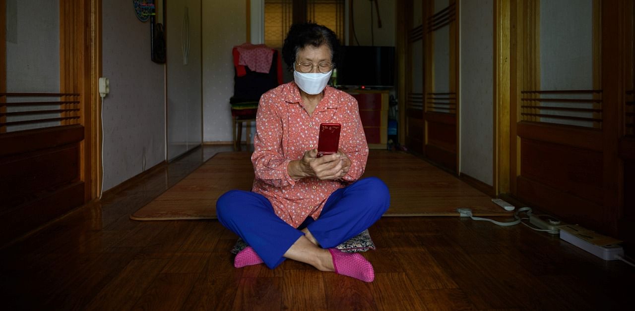 83-year-old Moon Haeng-ja sits in her home following a visit from a local authority home help worker who was teaching her how to make video calls with her family ahead of the Chuseok festival. Credit: AFP Photo