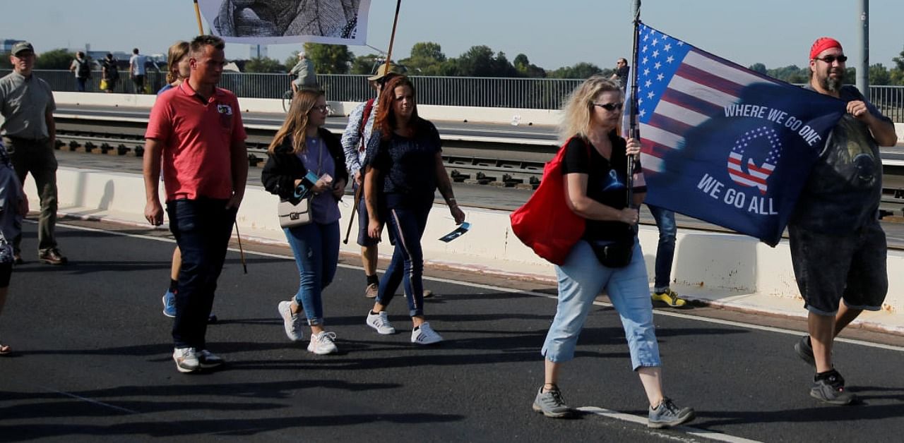 QAnon supporters are seen during a protest against coronavirus measures in Duesseldorf, Germany. Credit: Reuters