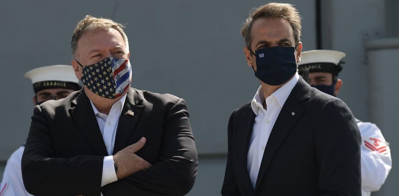 US Secretary of State Mike Pompeo (L) and Greek Prime Minister Kyriakos Mitsotakis stand in front of the Greek Naval frigate Salamis during their visit to the Naval Support Activity base at Souda, the foremost US naval facility in the eastern Mediterranean on the Greek island of Crete. Credit: AFP