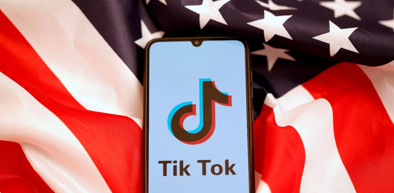 TikTok's logo is displayed on the smartphone while standing on the US flag. Credit: Reuters Photo