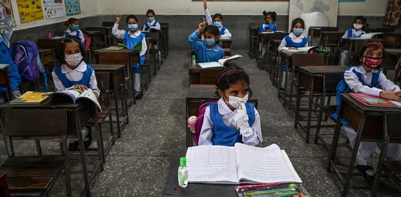 Children wearing facemasks attend a class at a school in Islamabad. Credit: AFP Photo