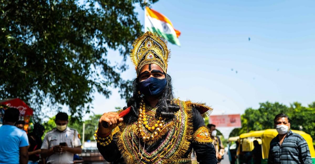 An officer from the District Magistrate Office dressed as Hindu lord of death and justice, Yamraj (C), looks for people not wearing facemasks as a preventive measure against the Covid-19 coronavirus in a public place in New Delhi on September 28, 2020. Credit: PTI Photo