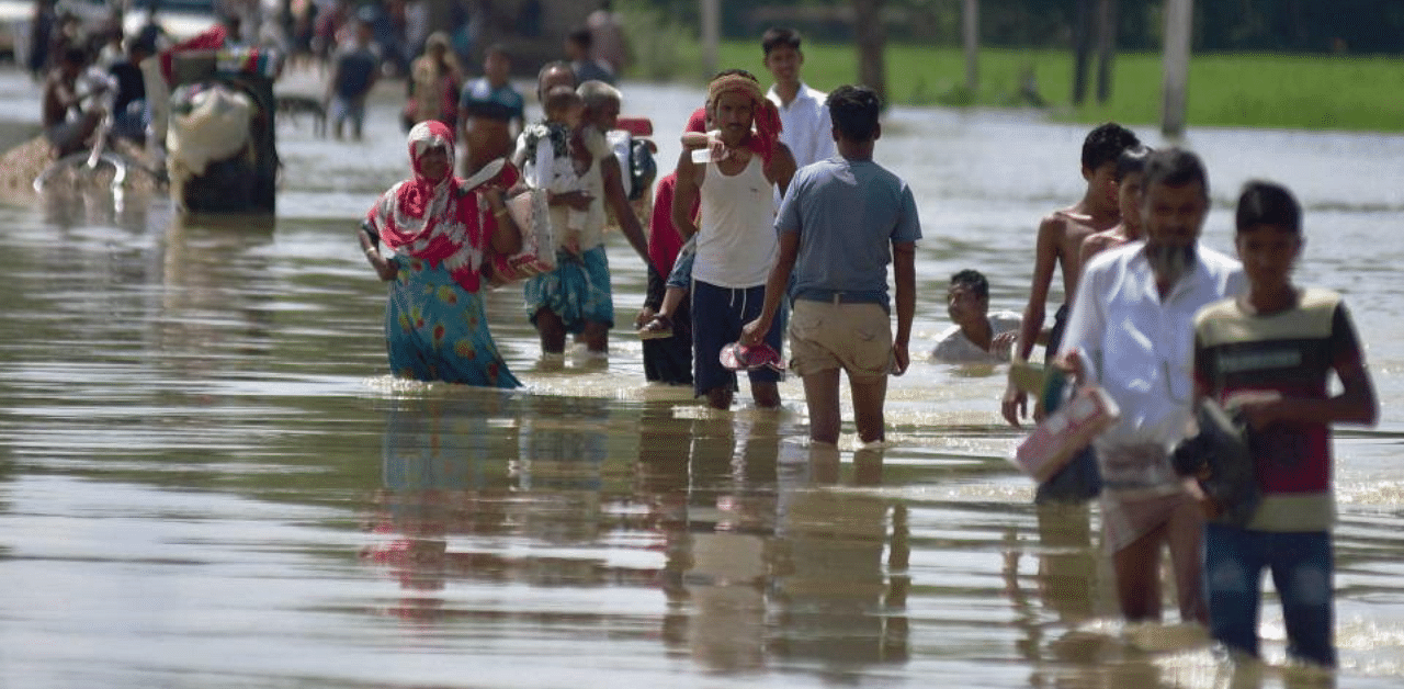 Villagers wade through a flooded road after heavy rainfall, in Hojai district of Assam, Tuesday, Sept. 29, 2020. Credit: PTI Photo