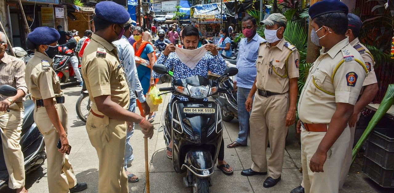 Police stop a commuter for not wearing face mask, amid the ongoing coronavirus pandemic, in Thane district. Credit: PTI Photo