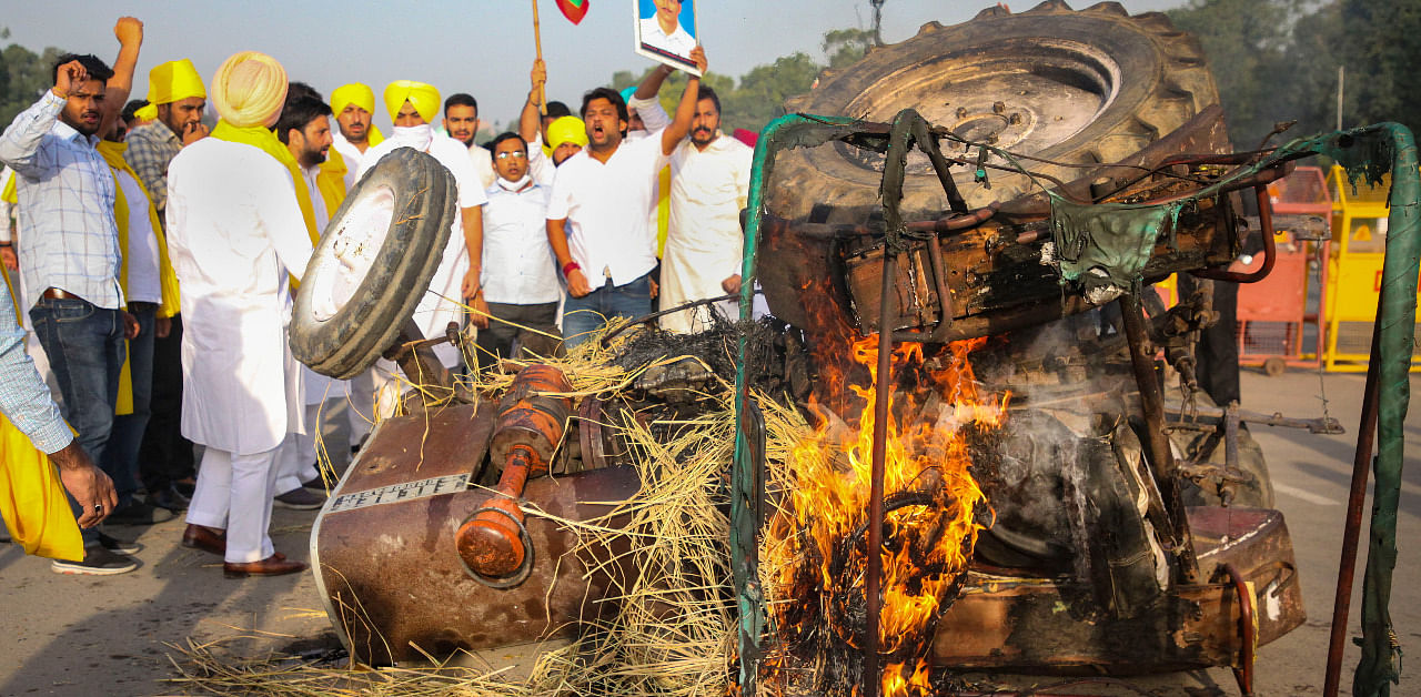 Punjab Youth Congress activists set on fire a tractor near India Gate during a protest against the new farm laws, in New Delhi. Credit: PTI Photo