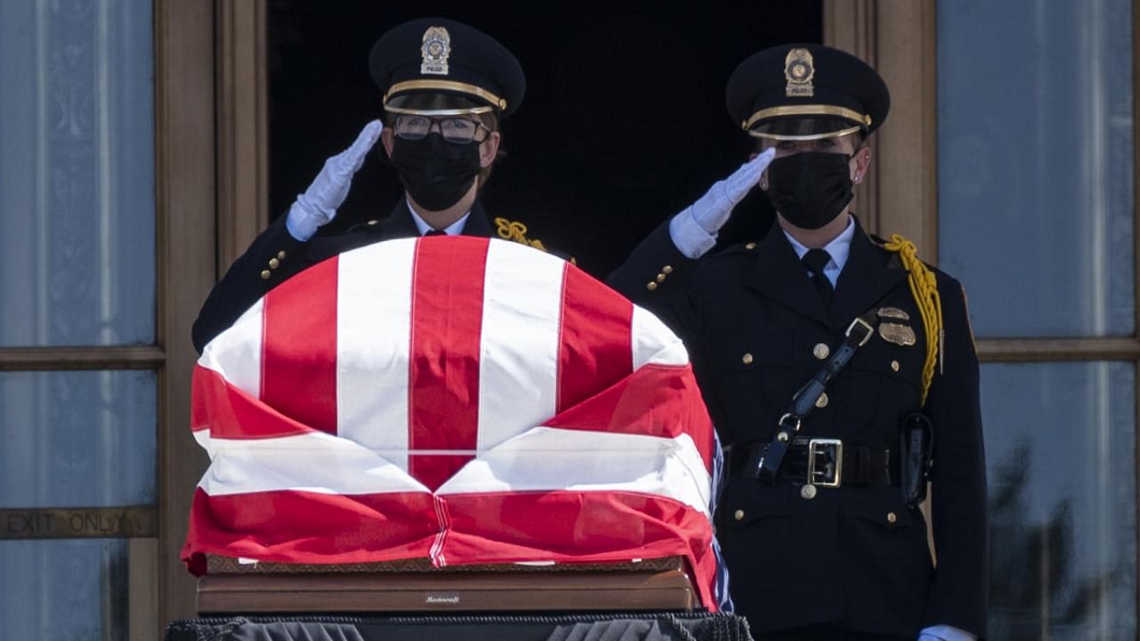 In this file photo two police officers salute near the casket of the late Supreme Court Justice Ruth Bader Ginsburg lying in repose at the Supreme Court in Washington, DC. Credit: AFP.