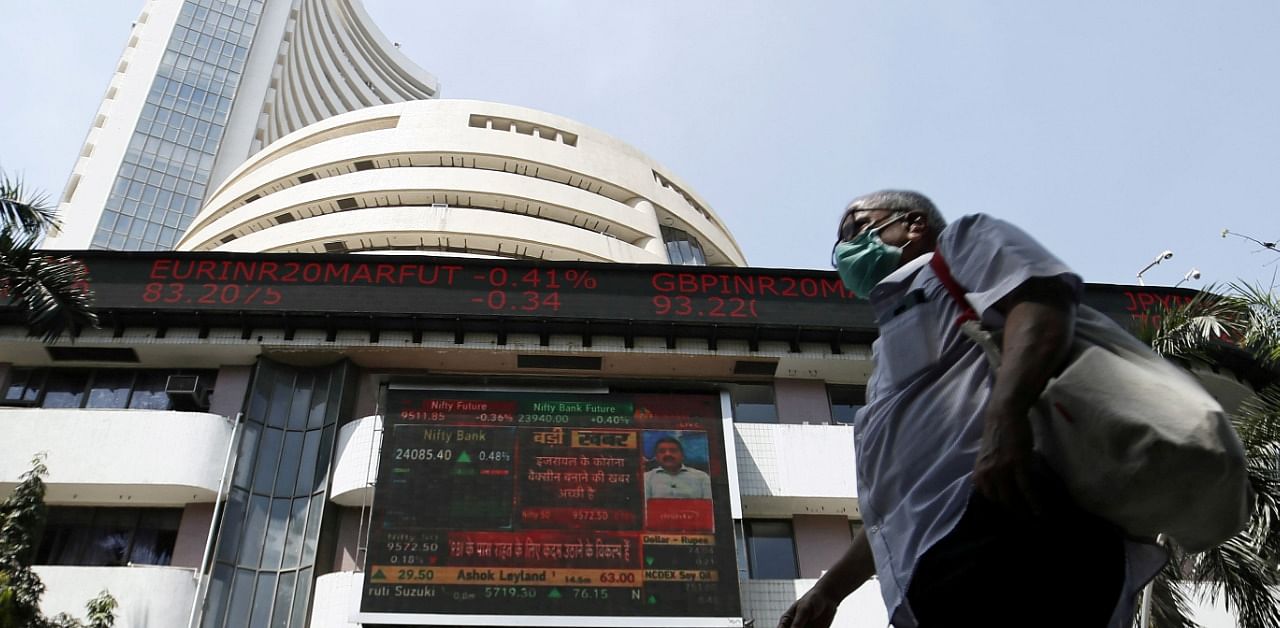 A man wearing a protective mask walks past the Bombay Stock Exchange (BSE) building. Credit: PTI Photo