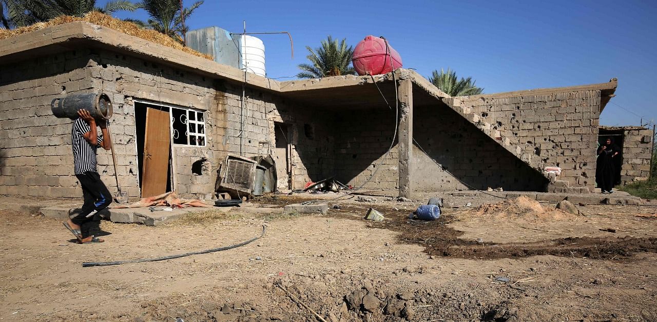 Iraqis clean up a house damaged by a rocket the previous day near Baghdad airport on the outskirts of the Iraqi capital on September 29. Credit: AFP Photo