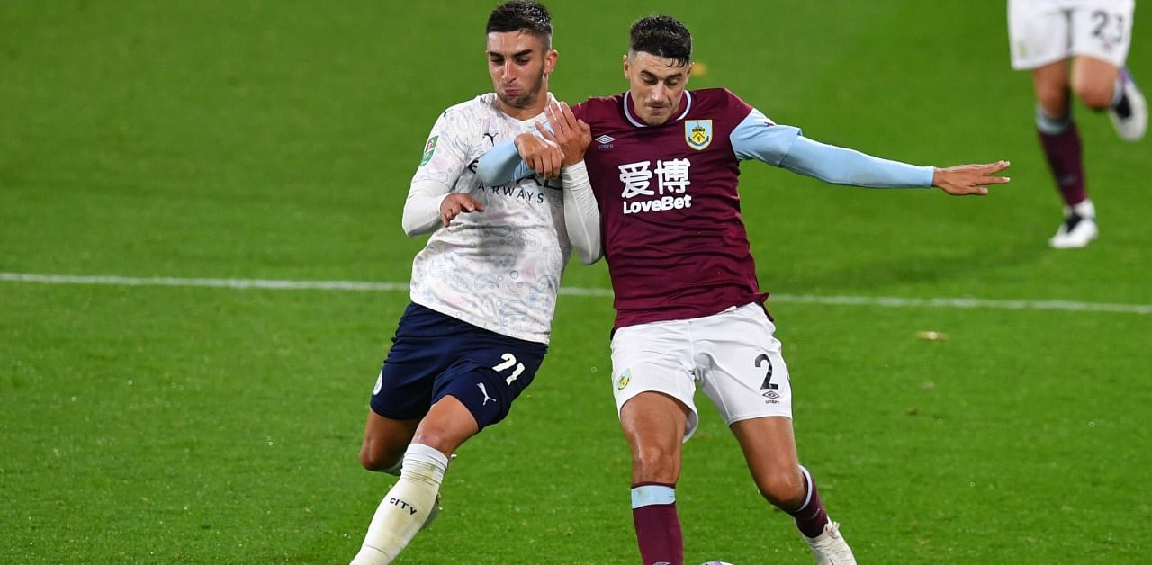 Manchester City's Spanish midfielder Ferran Torres (L) vies with Burnley's English defender Matthew Lowton (R) during the English League Cup fourth round football match between Burnley and Manchester City at Turf Moor in Burnley, north west England. Credit: AFP Photo