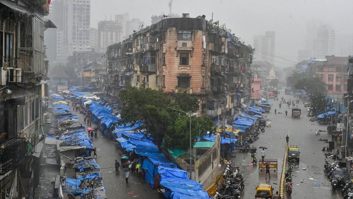 People wade through waterlogged streets following heavy rains, at Bhendi Bazaar in Mumbai. Credit: PTI.