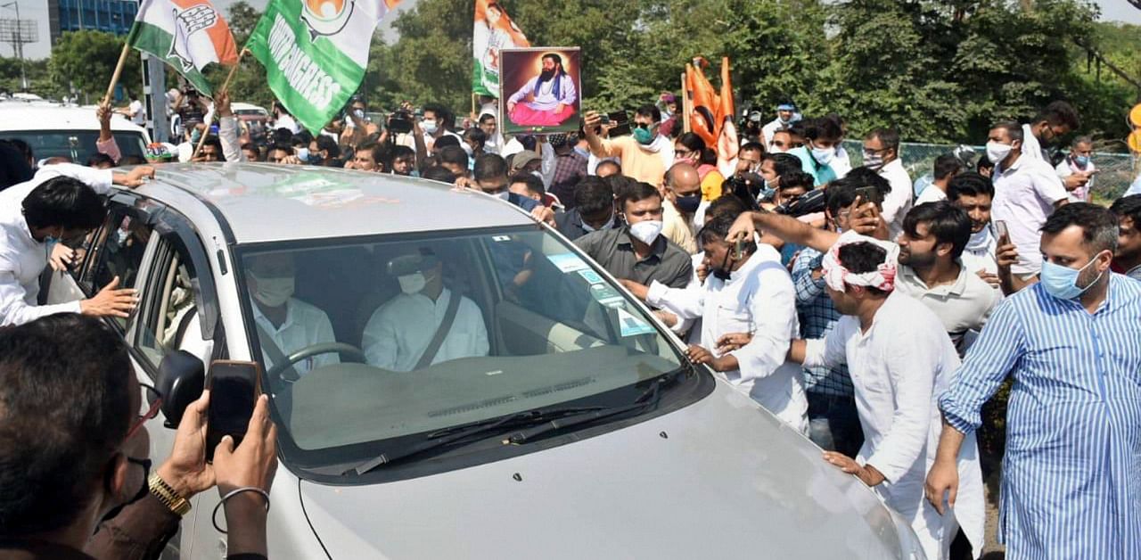 Former Congress President Rahul Gandhi's supporters wave party flags near his car on the DND Flyway, while he was on the way to Hathras to meet Dalit rape victim's family. Credit: PTI Photo