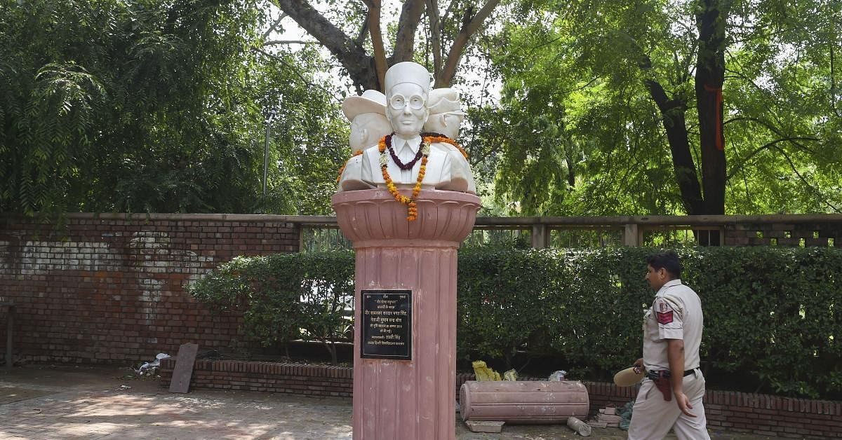 A policeman walks past the busts of Veer Savarkar, Subhash Chandra Bose and Bhagat Singh installed outside the Arts Faculty of Delhi University, in New Delhi. Credit: PTI Photo 