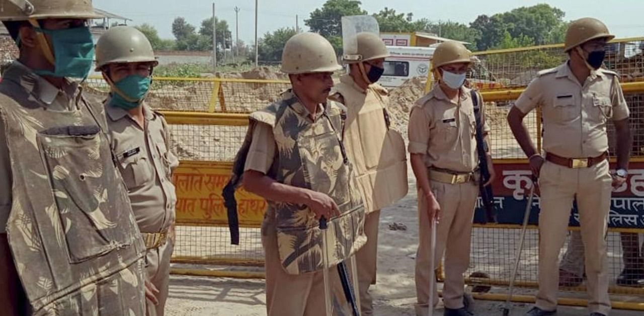 Police personnel stand guard at the entrance of Bulgadi village where the family of 19-year-old Dalit woman who was gang-raped two weeks ago resides, in Hathras district, Thursday, Oct. 1, 2020. (PTI Photo)