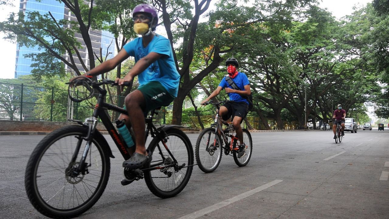 People cycle at Sampangi Rama Nagar near Cubbon Park as several parks in the city is open after the lockdown in Bengaluru on Tuesday. DH Photo/ Pushkar V