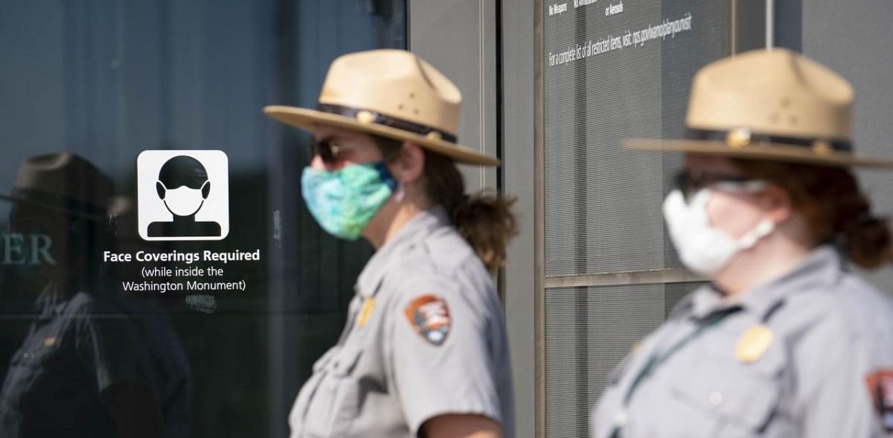 US National Park Service Rangers wear protective face masks as they interact with visitors. Credit: AFP