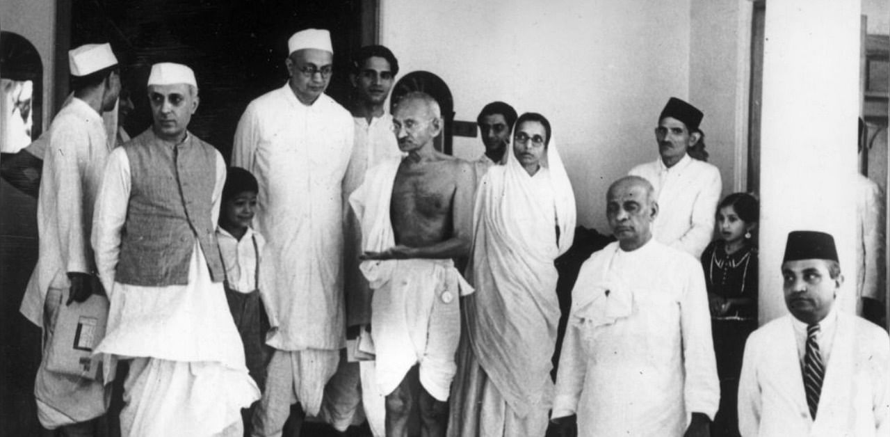 Indian freedom dighter Mahatma Gandhi (Mohandas Karamchand Gandhi, 1869 - 1948), centre, waiting for a car outside Bifla House, Bombay, on his return from Rajkoy. Amongst the group with him are Pandit Nehru (1869 - 1964) (left) and Vallabhai Patel (right). Credit: Getty Images