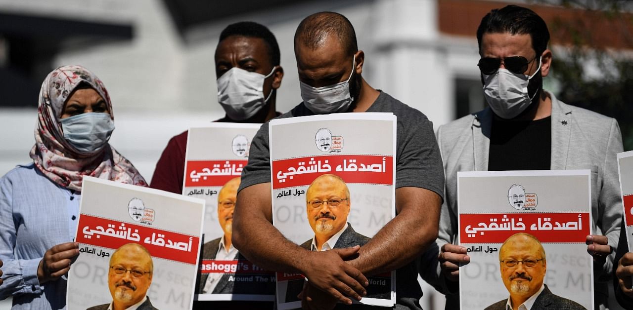 Friends of murdered Saudi journalist Jamal Khashoggi hold posters bearing his picture as they attend an event marking the second-year anniversary of his assassination. Credit: AFP Photo