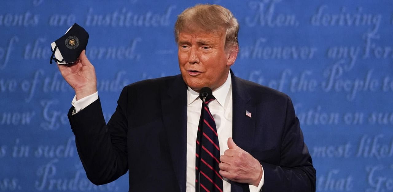 US President Donald Trump holds up his face mask during the first presidential debate. Credit: AP