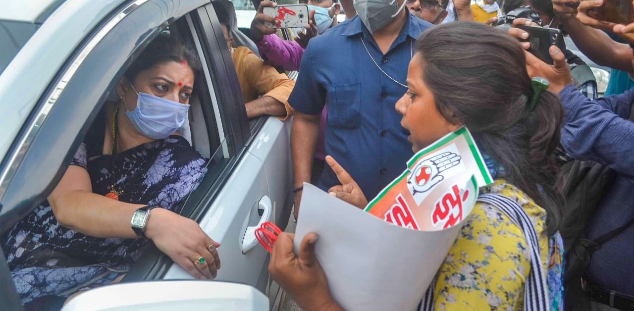 A Congress party activist protests near the vehicle of Union Minister Smriti Irani, over the death of a 19-year-old Dalit woman after an alleged gangrape in UP's Hathras. Credit: PTI Photo
