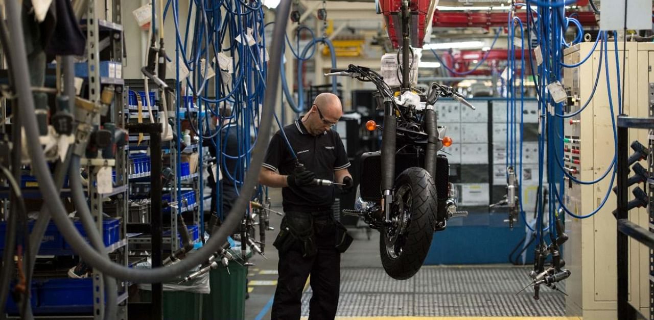 Employees assemble motorcycles on the assembly line at the Triumph Motorcycles factory in Hinckley, central England. Credit: AFP