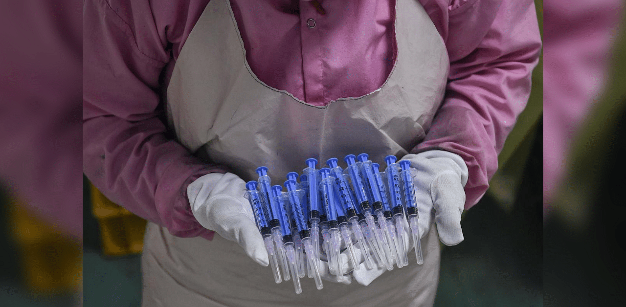 In this photograph taken on September 2, 2020, a worker displays syringes at the Hindustan Syringes factory in Faridabad. - India's biggest syringe manufacturer is ramping up its production to churn out a billion units, anticipating a surge in demand as the global race to find a coronavirus vaccine heats up. Credit: AFP Photo