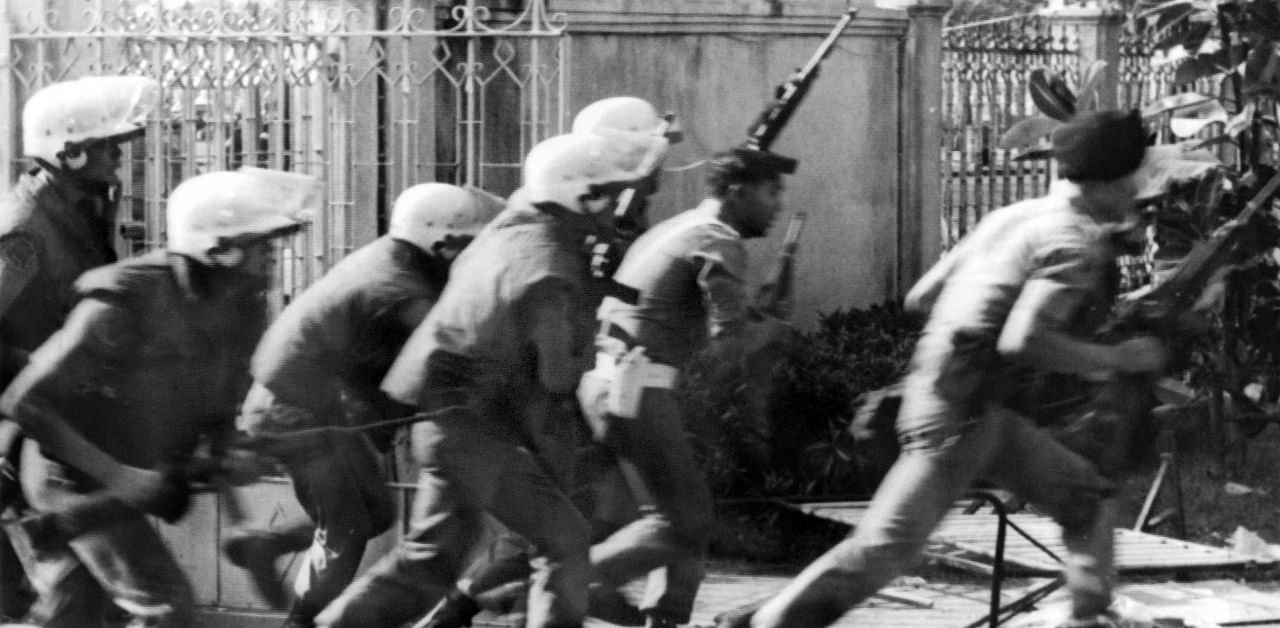 In this file photo taken on October 6, 1976, armed police run into Thammasat University in Bangkok, during a confrontation with students on campus when students protesting the return of a military dictator were shot, beaten to death and lynched by state forces and royalist mobs. Credit: AFP Photo