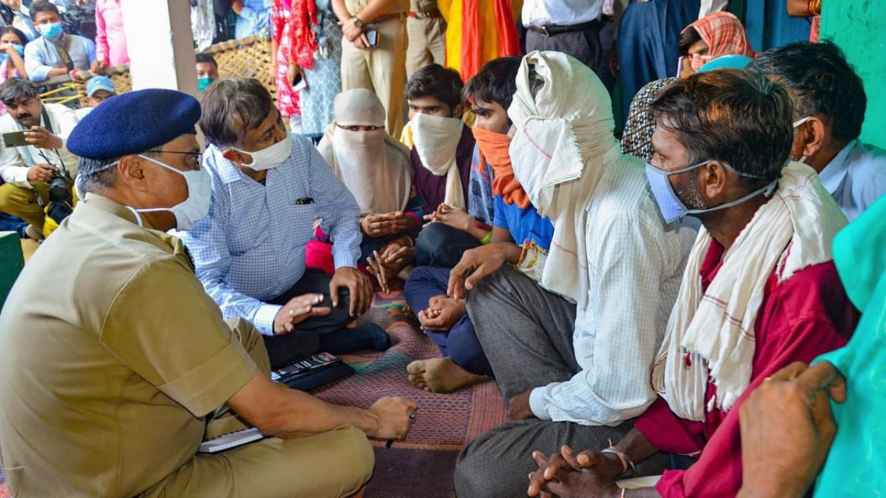 Additional Chief Secretary of Uttar Pradesh Awanish Kumar Awasthi meets the family members of a 19-year-old Dalit woman who died after being allegedly raped two ago, at Bulgadi village in Hathras. Credit: PTI.