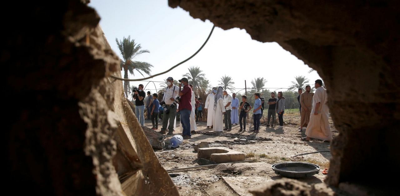 People are seen through a hole of a house damaged by a rocket attack in Iraq (representative image). Credit: Reuters