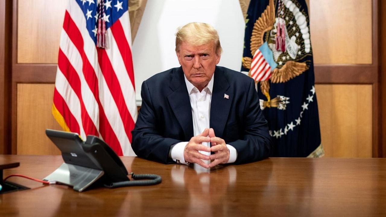 This handout photo shows US President Donald Trump and his Chief of Staff (not pictured) participating in a phone call with the US Vice President, Secretary of State and Chairman of the Joint Chiefs of Staff on October 4, 2020, in his conference room at Walter Reed National Military Medical Center in Bethesda. Credit: AFP/Tia DUFOUR / The White House