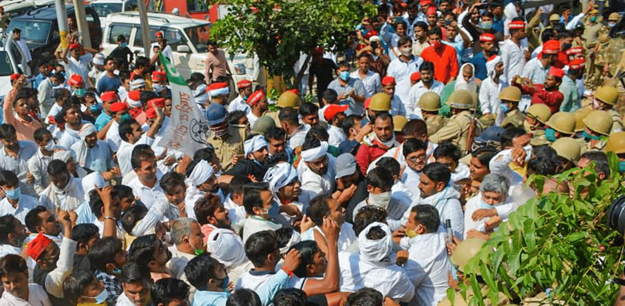 Police personnel try to stop RLD and Samajwadi Party workers during their visit to meet the family members of a 19-year-old Dalit woman who was allegedly gang-raped two weeks ago, in Hathras, Sunday, Oct. 4, 2020. Credit: PTI Photo